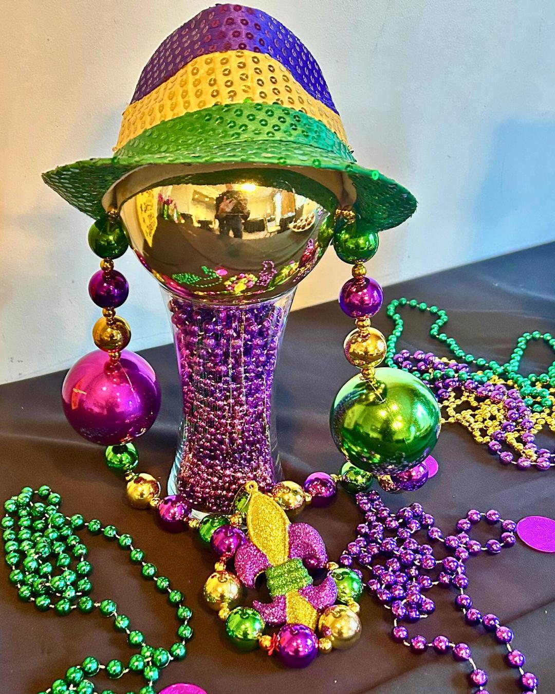 Mardi Gras centerpiece with sequined hat, beads, and ornaments used for New Orleans corporate events and creative team building décor.