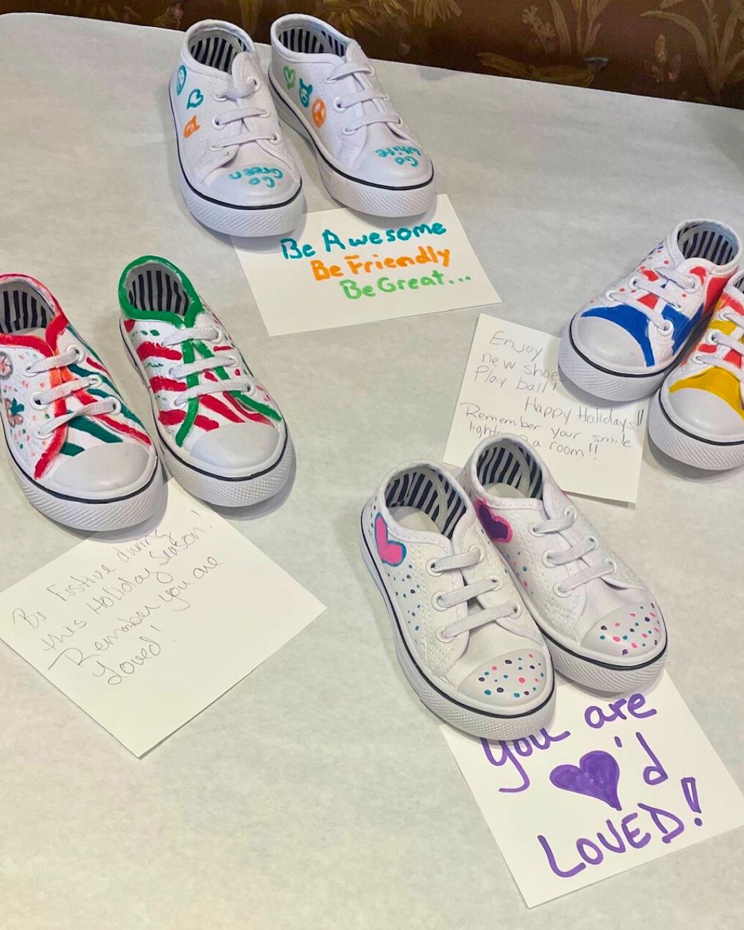 Painted children’s shoes and handwritten encouragement notes prepared during a New Orleans corporate giveback workshop supporting local families.
