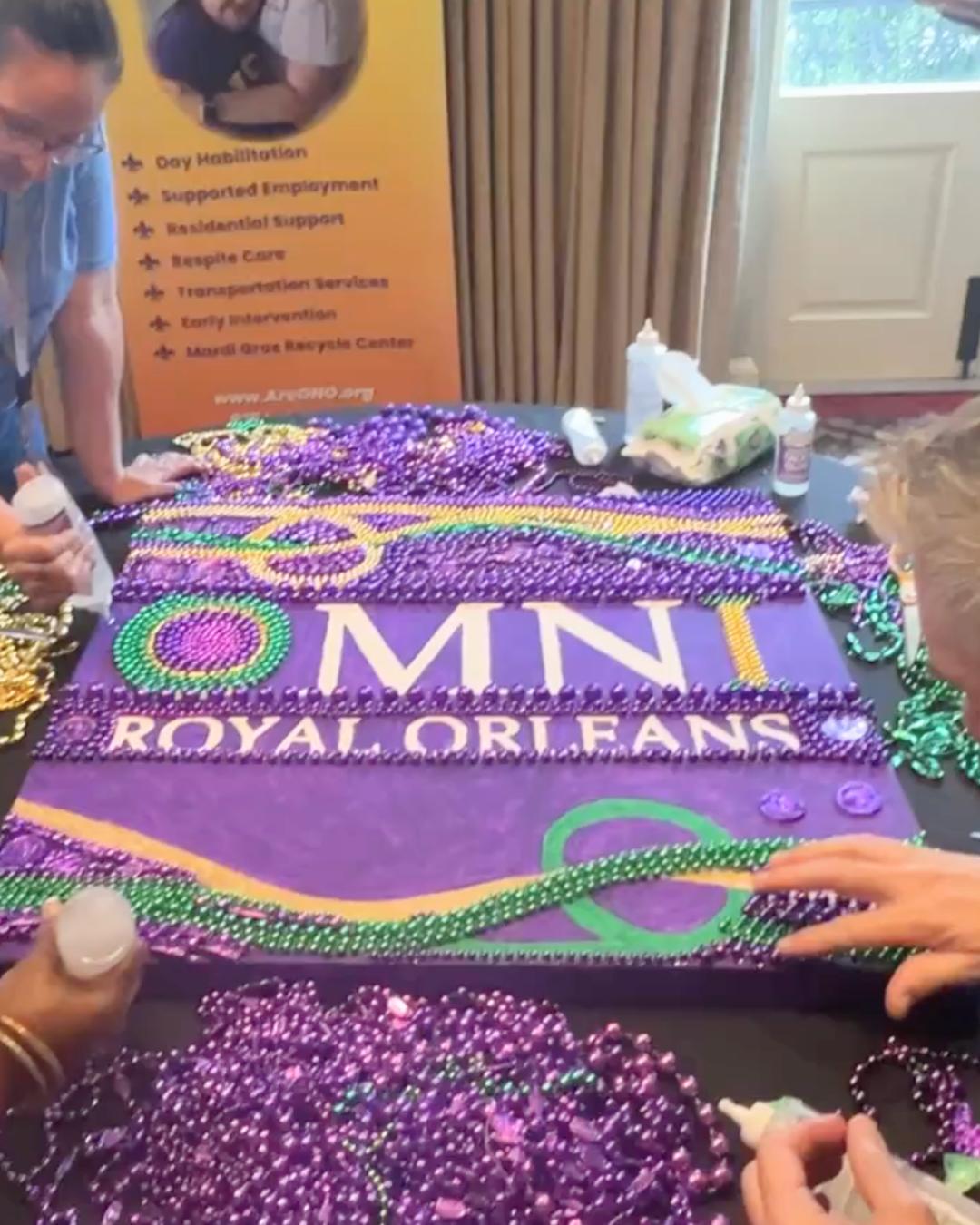 Teams creating a bead art logo for Omni Royal Orleans during a New Orleans corporate giveback workshop in partnership with ARC of Greater New Orleans.