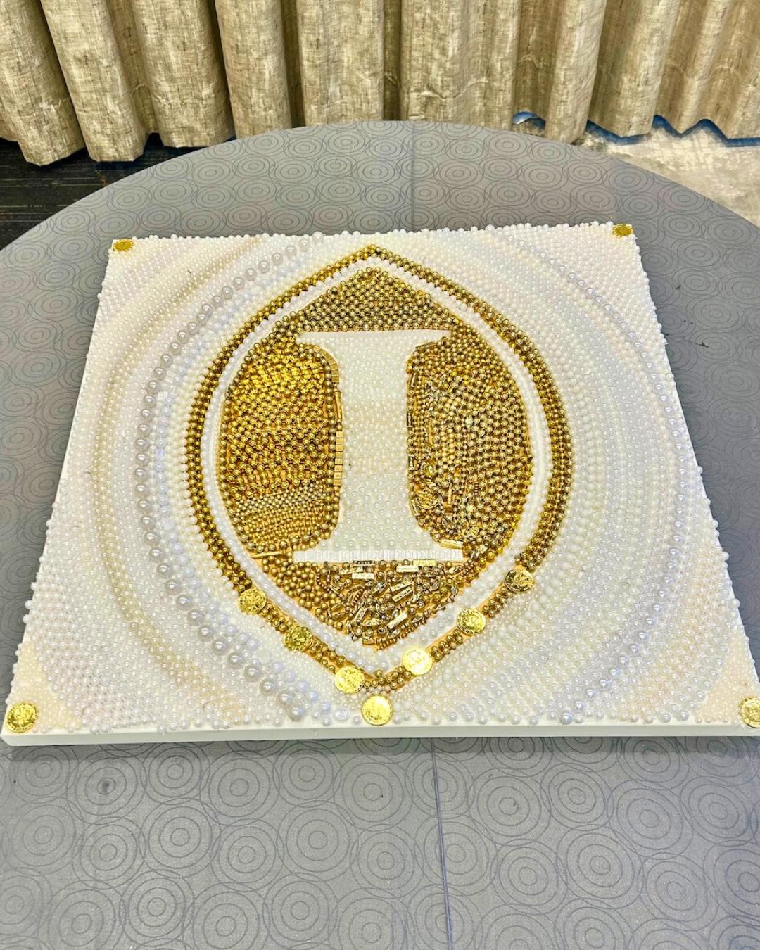 Finished gold and white bead crest artwork of the Intercontinental Hotel, created in an ACCENT New Orleans DMC corporate team building workshop.